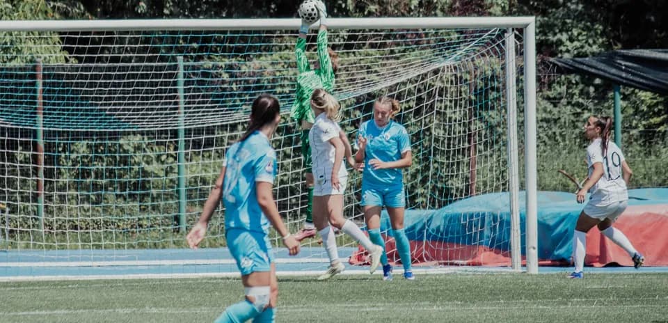 Portera atrapando el balón en el partido