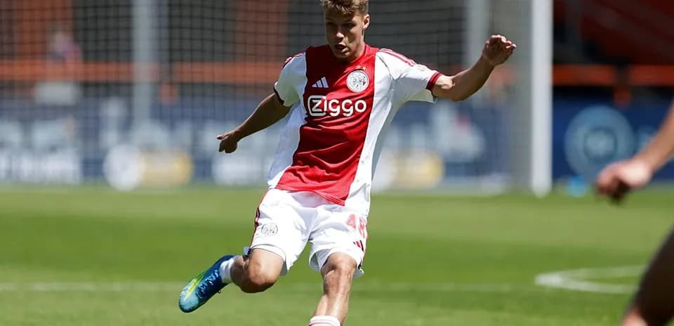 Jugador de Ajax ejecutando un pase en el campo