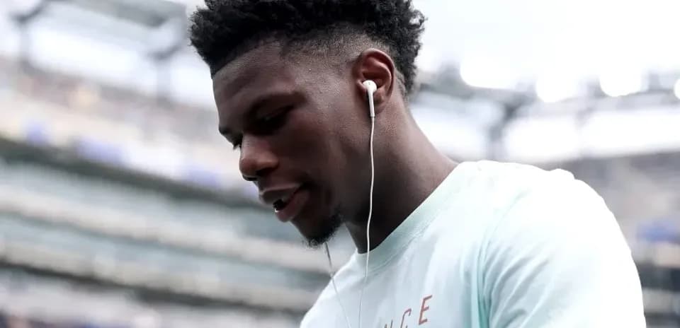 Jugador escuchando música con auriculares en el estadio