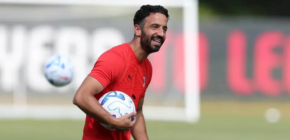 Jugador entrenando y sosteniendo balones en campo
