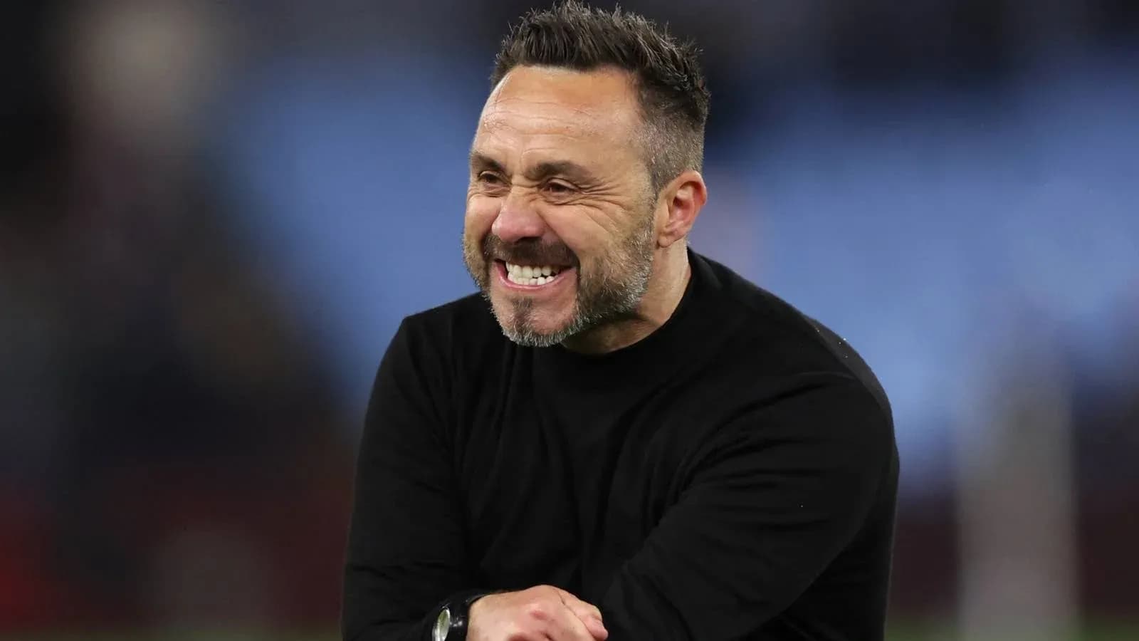 Entrenador sonriente en el campo de fútbol