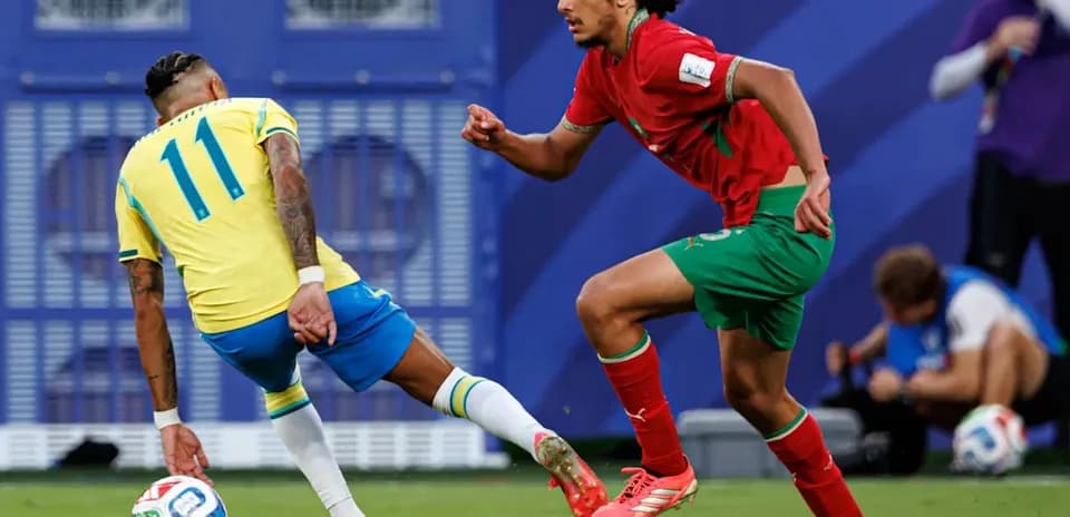 Jugador brasileño driblando a rival marroquí en partido