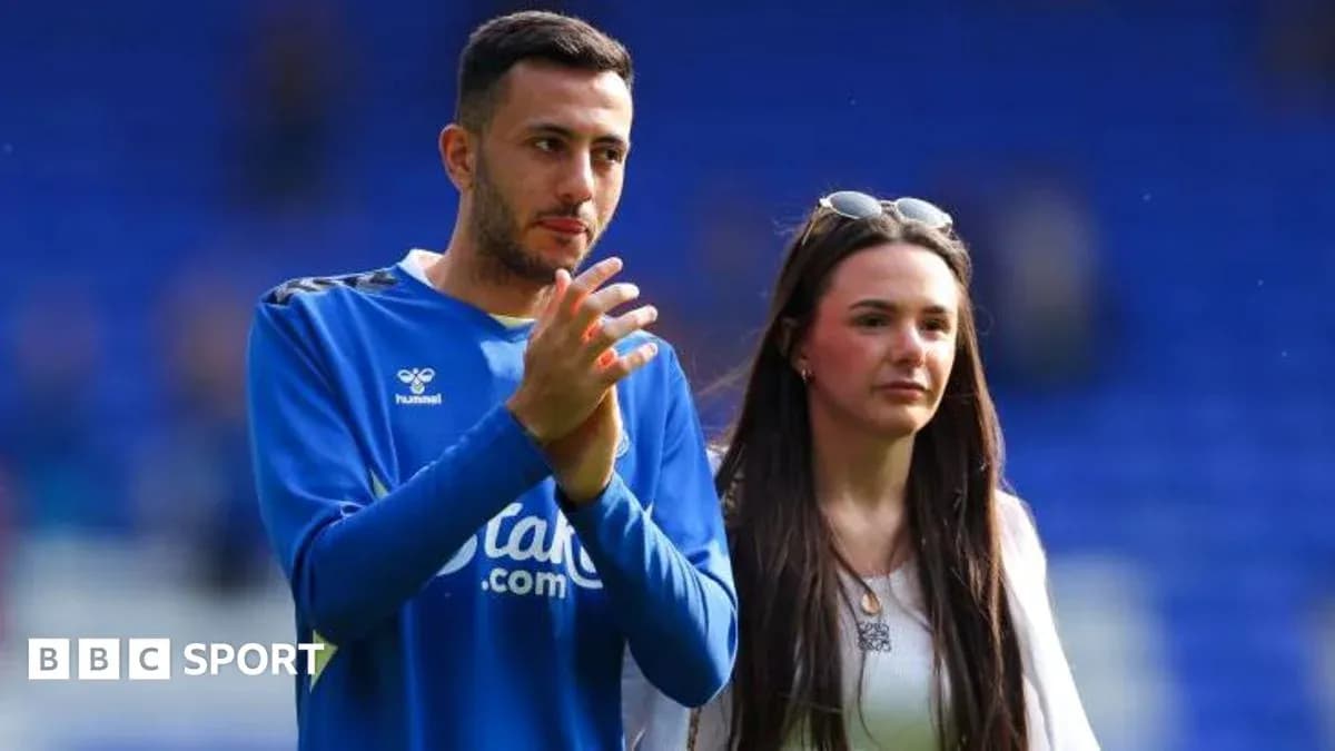 Jugador aplaudiendo junto a una mujer en el campo