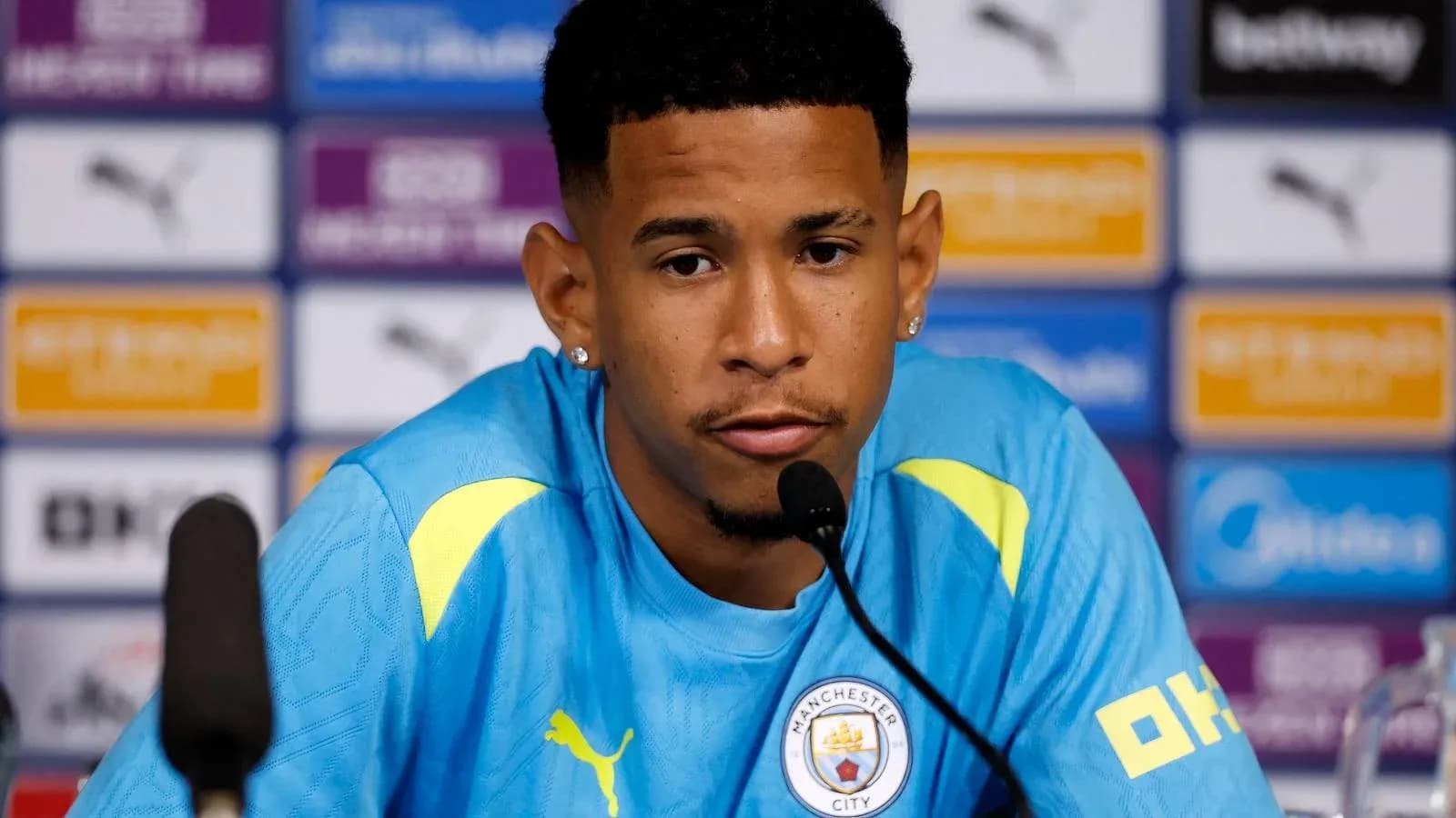 Jugador en conferencia de prensa con camiseta de Manchester City