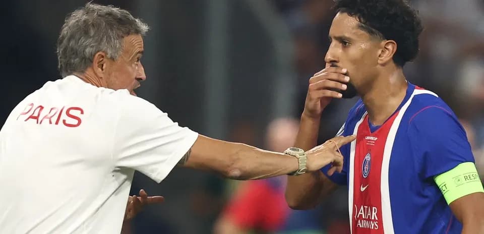 Entrenador hablando con jugador de PSG durante partido