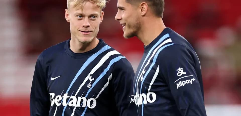 Dos jugadores conversando en el campo de entrenamiento