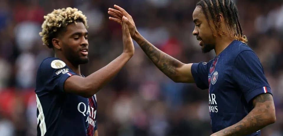 Jugadores de PSG chocando las manos en el campo