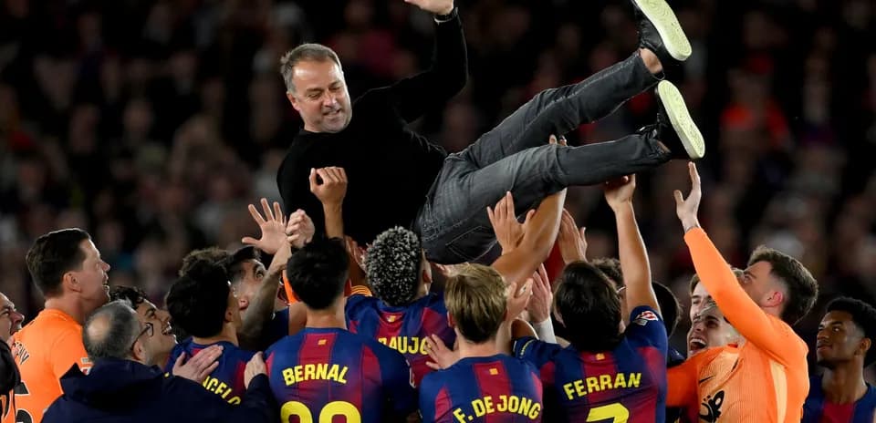 Entrenador siendo levantado por jugadores del FC Barcelona