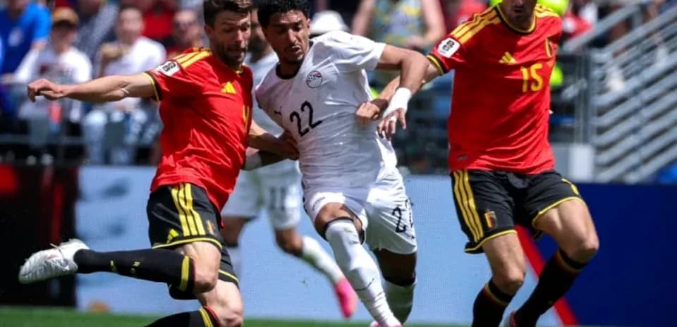 Jugador de Egipto luchando por el balón contra dos jugadores belgas