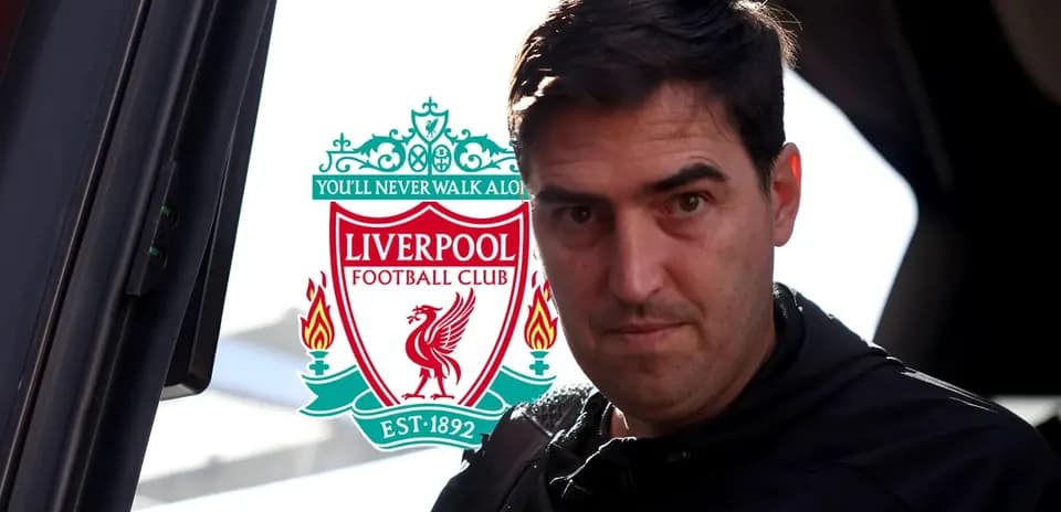 Entrenador llegando con logo de Liverpool de fondo