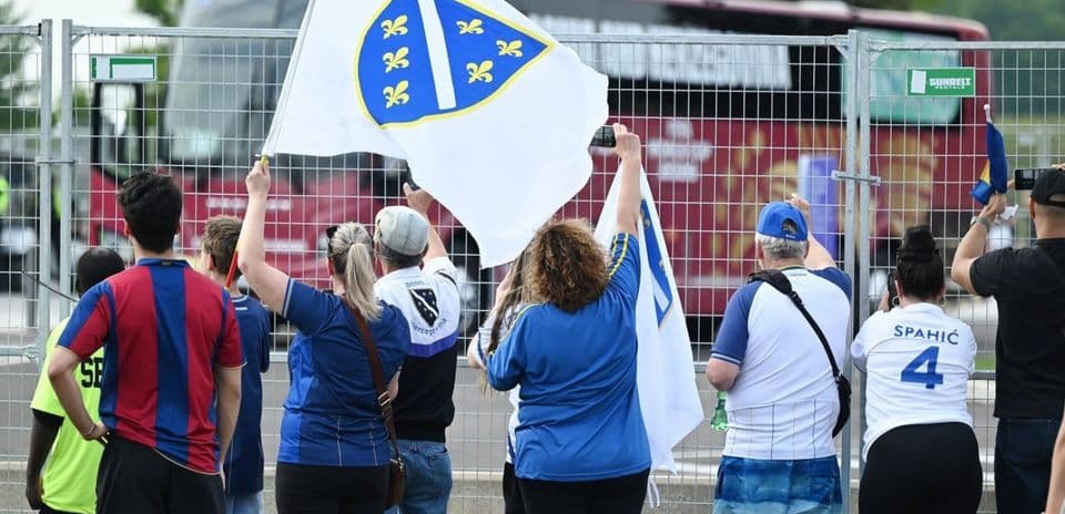Aficionados sosteniendo banderas de Bosnia y Herzegovina