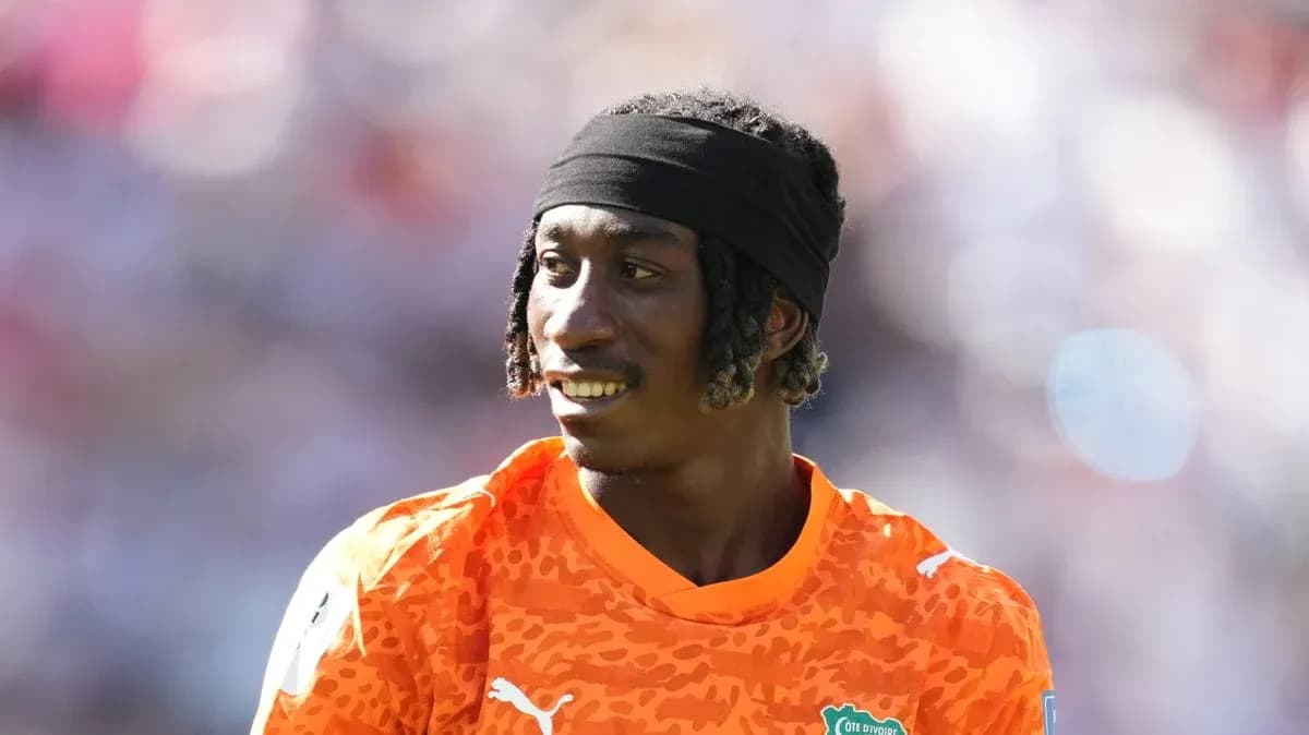 Jugador con camiseta naranja sonriendo en el campo