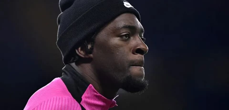 Jugador en calentamiento con camiseta rosa y gorro