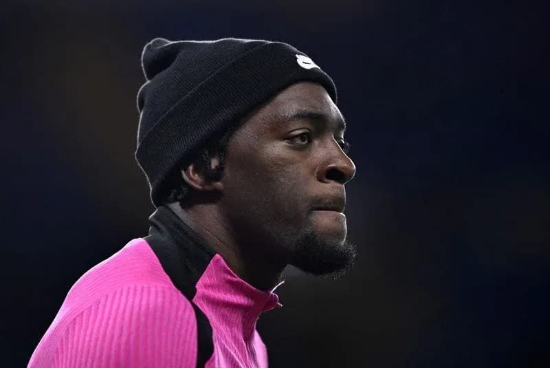 Jugador en calentamiento con camiseta rosa y gorro