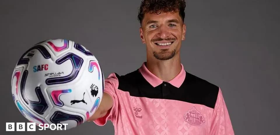 Jugador sosteniendo un balón de fútbol con sonrisa