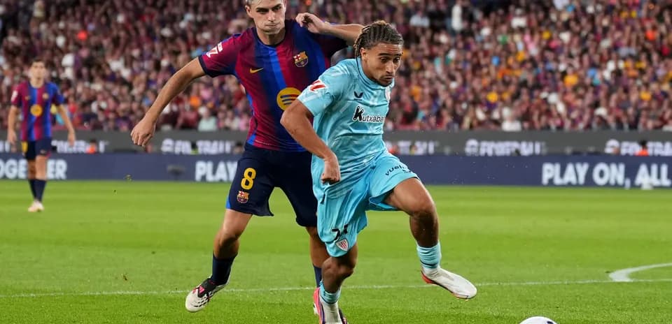 Jugador del Barcelona persiguiendo a rival en el campo