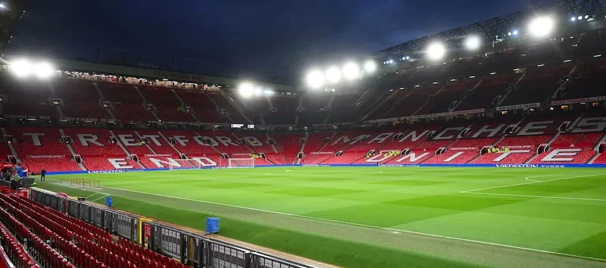 Estadio Old Trafford con asientos vacíos iluminados