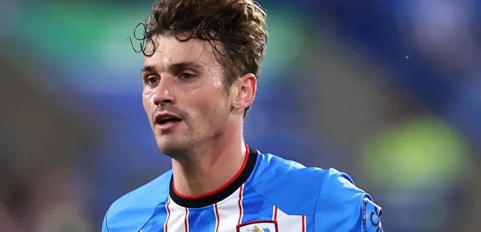 Jugador con camiseta de Huddersfield Town en acción