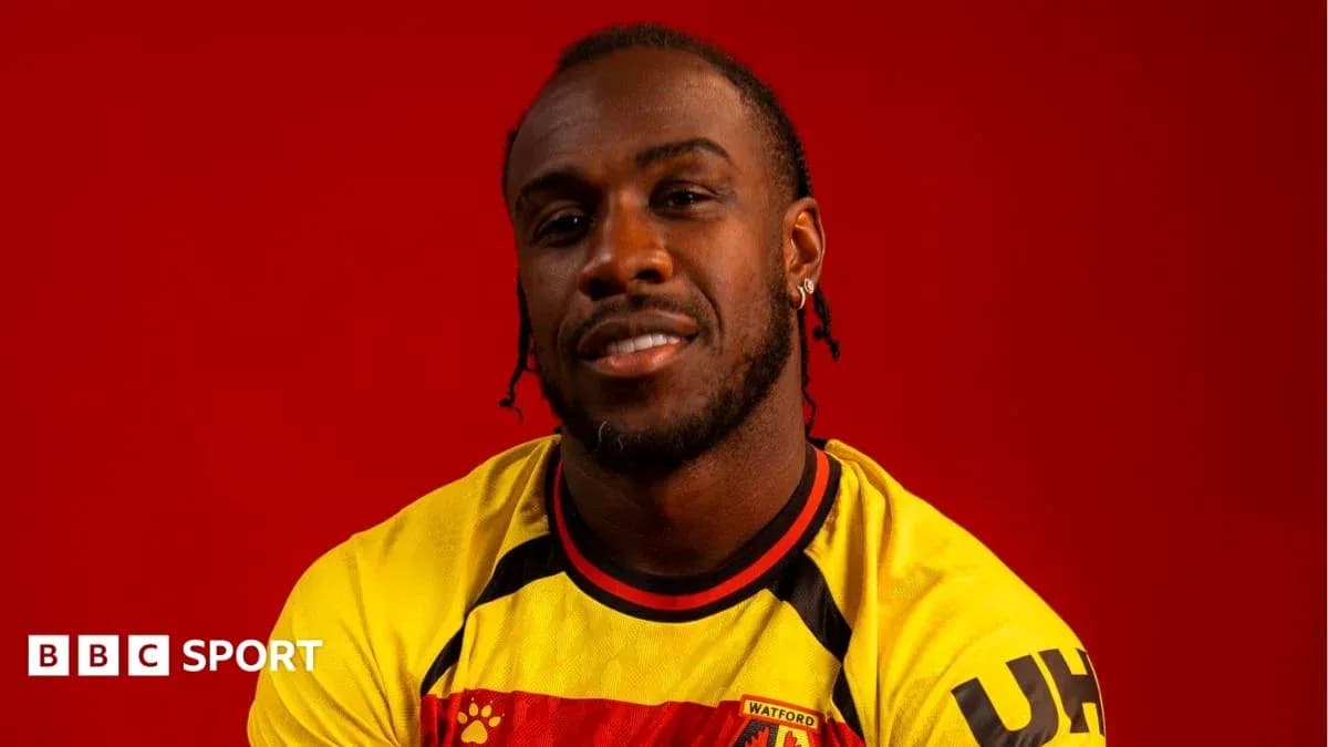 Jugador posando con camiseta de Watford frente fondo rojo