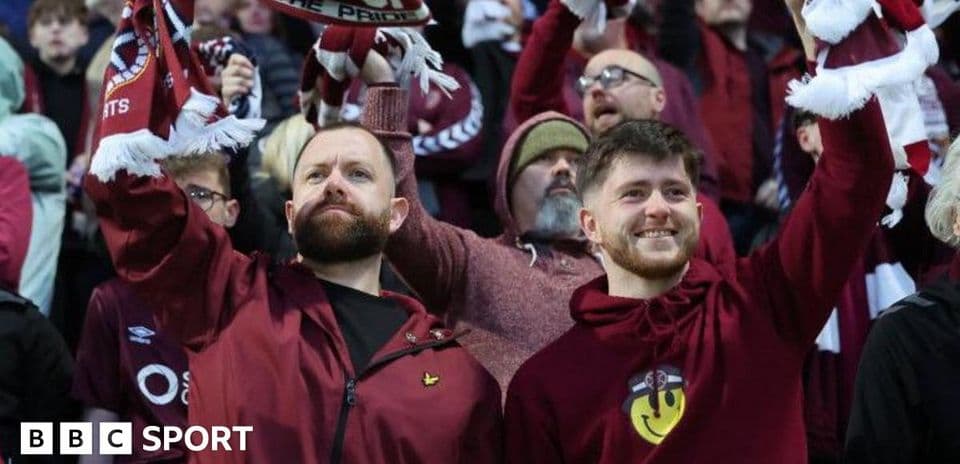 Aficionados sosteniendo bufandas en el estadio