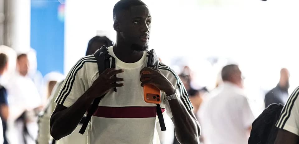 Jugador entrando con mochila y teléfono en mano