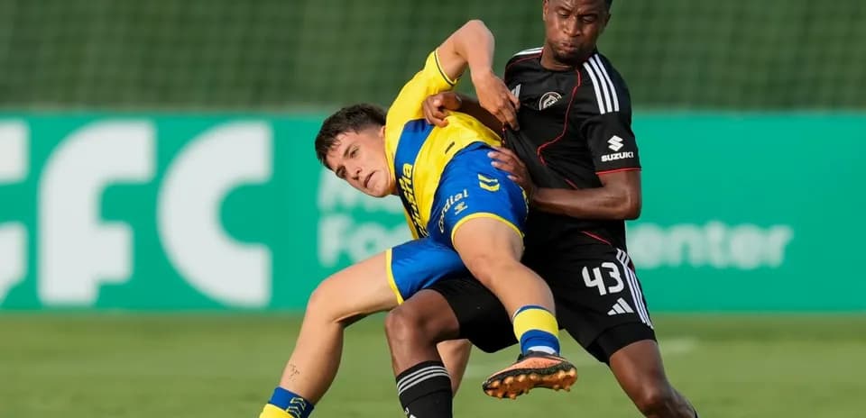 Dos jugadores luchando por el balón en el campo