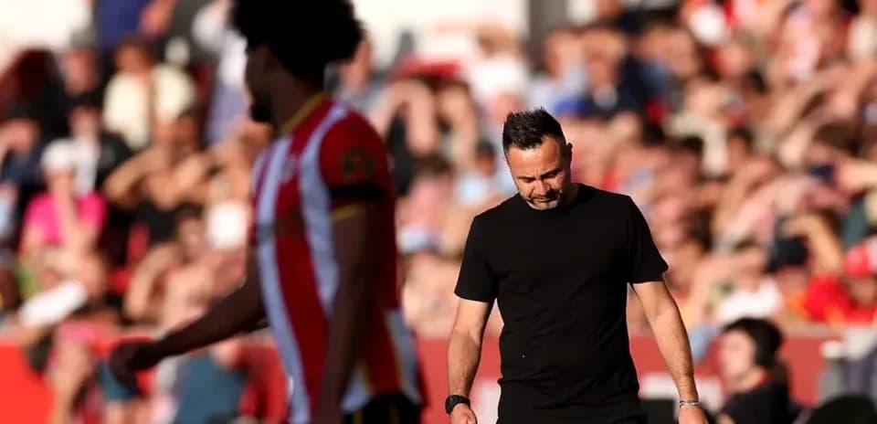 Entrenador caminando por la línea de banda durante partido