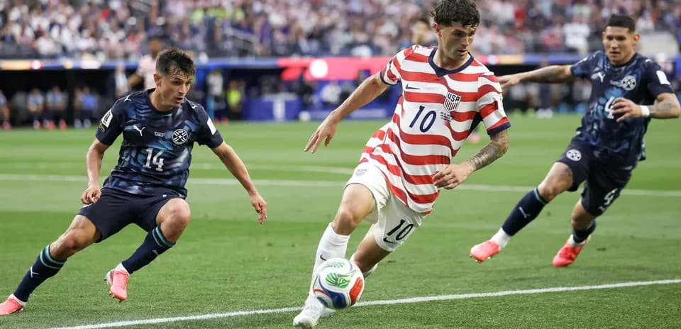 Cristian Pulisic dribbling past two defenders during match