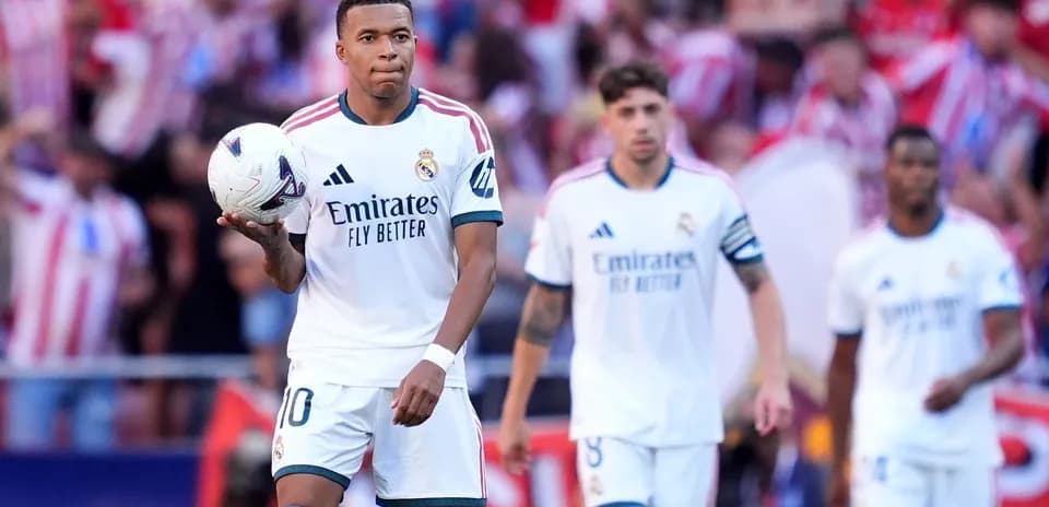 Kylian Mbappé sosteniendo el balón en el campo