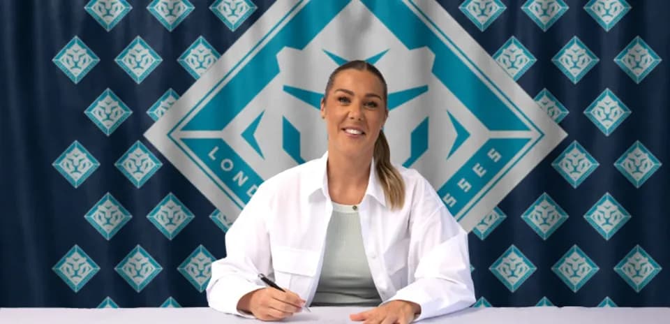 Jugadora firmando contrato en mesa con fondo de equipo