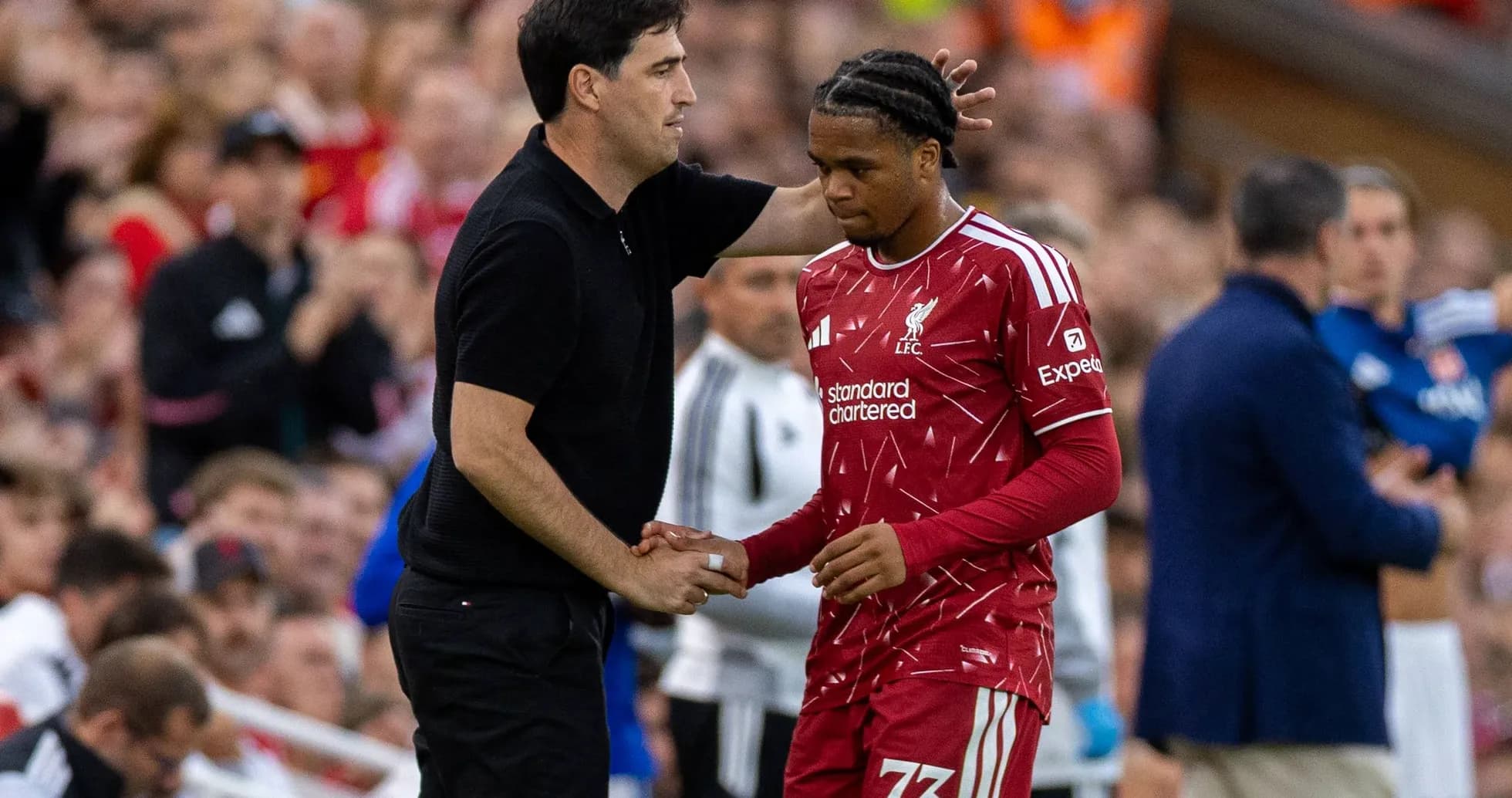 Entrenador hablando con jugador de Liverpool durante el partido