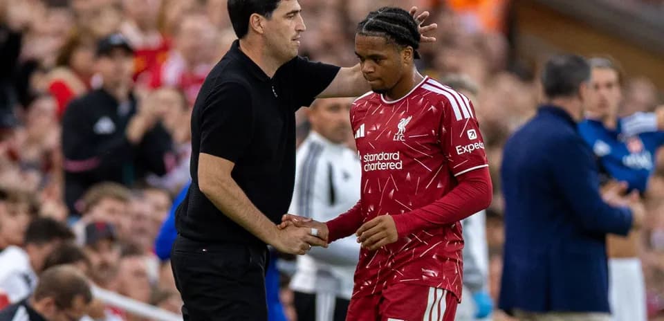 Entrenador hablando con jugador de Liverpool durante el partido