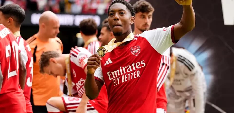 Jugador de Arsenal celebrando con medalla en mano