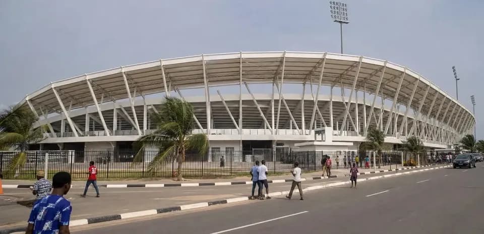 Estadio moderno con personas caminando afuera