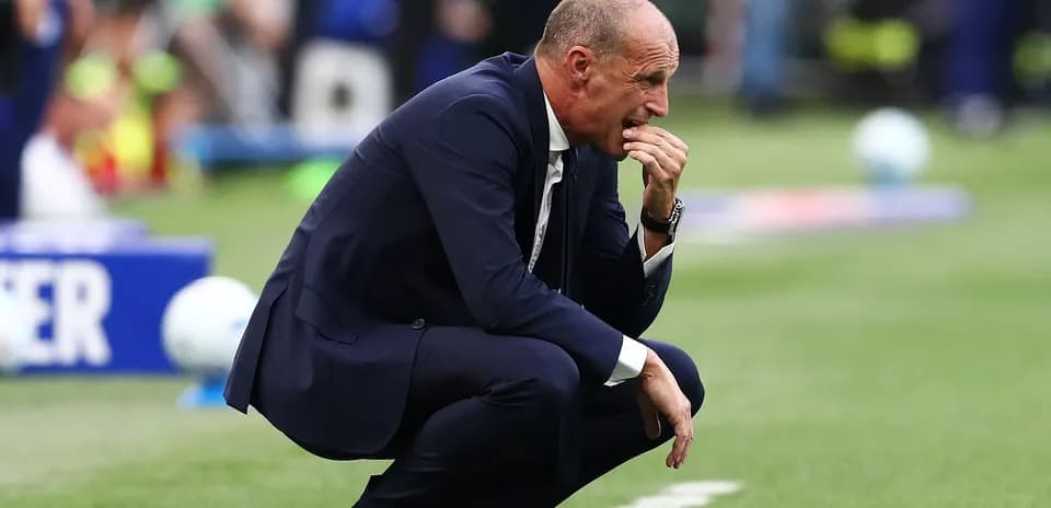 Entrenador agachado durante el partido en el campo