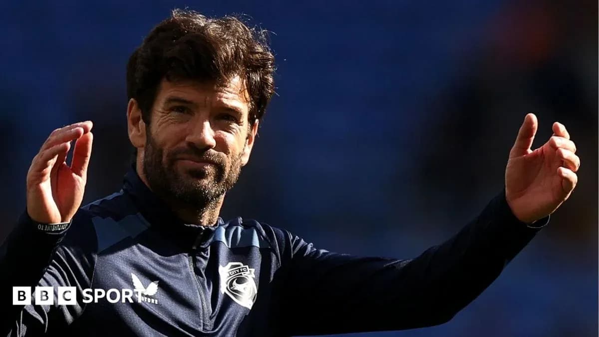Entrenador saludando al público en el estadio