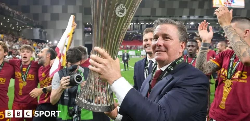 Entrenador sosteniendo el trofeo de la Europa League