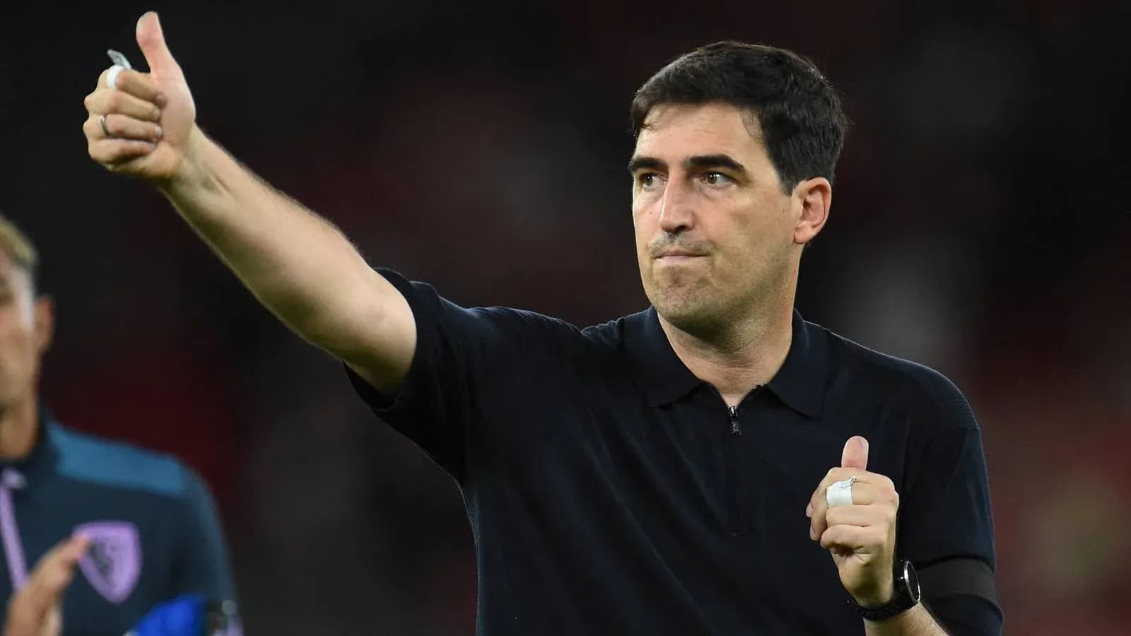Entrenador señalando con pulgar hacia arriba