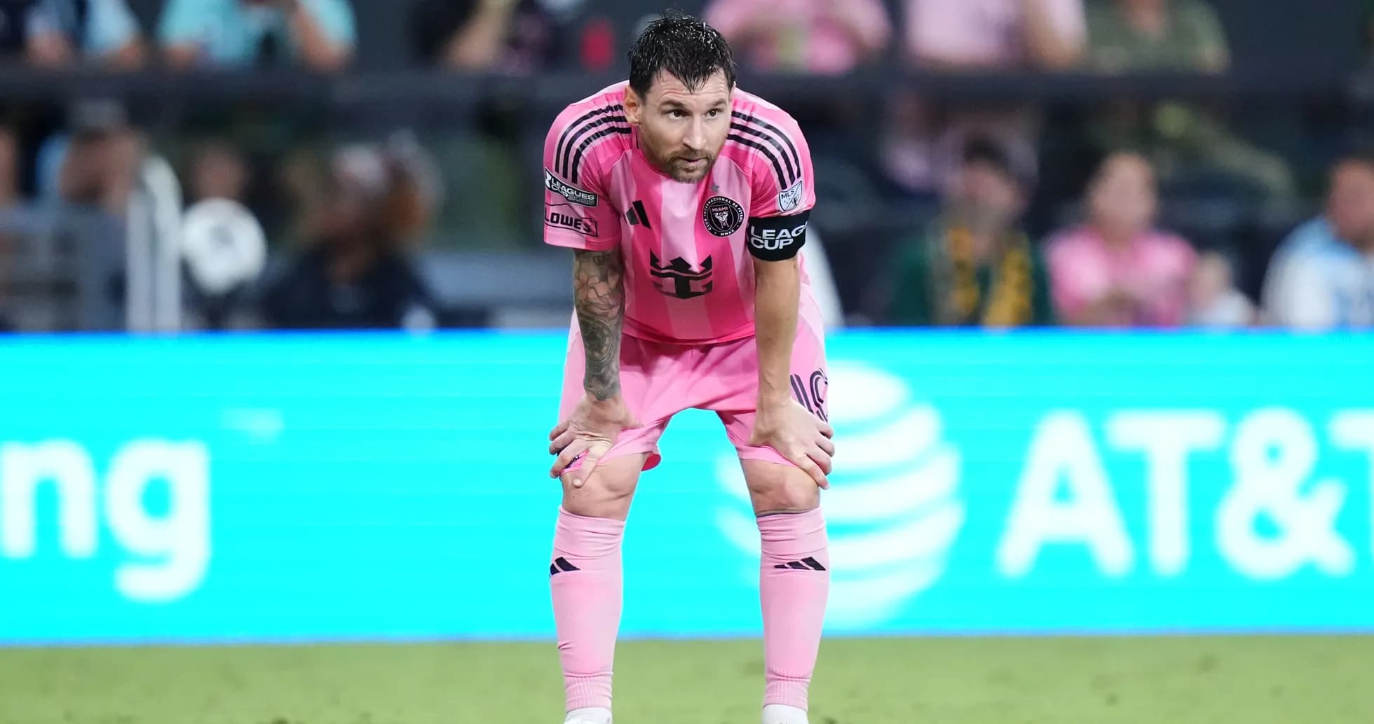 Jugador en uniforme rosa descansando durante el partido