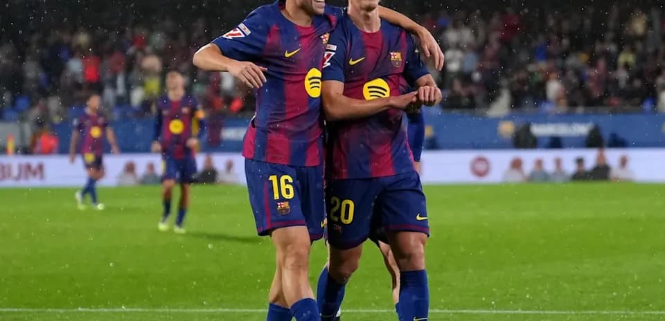 Jugadores del FC Barcelona celebrando un gol bajo la lluvia