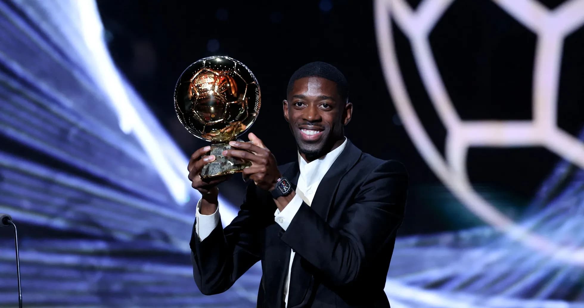Jugador sosteniendo el Balón de Oro en escenario