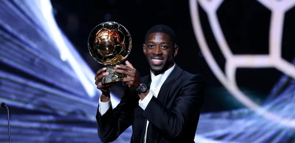 Jugador sosteniendo el Balón de Oro en escenario