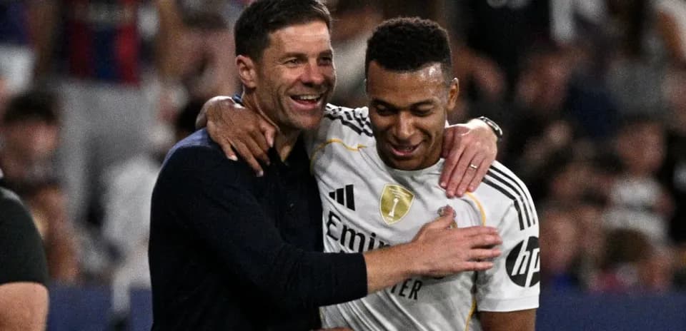 Entrenador y jugador celebrando en el campo