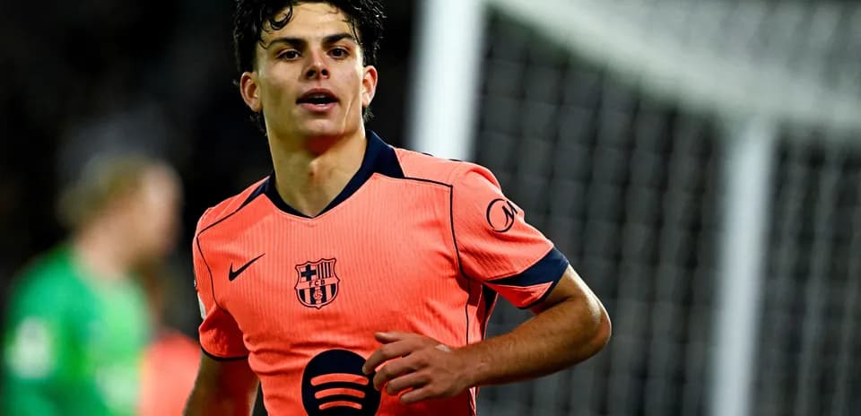 Jugador de FC Barcelona en camiseta naranja durante partido