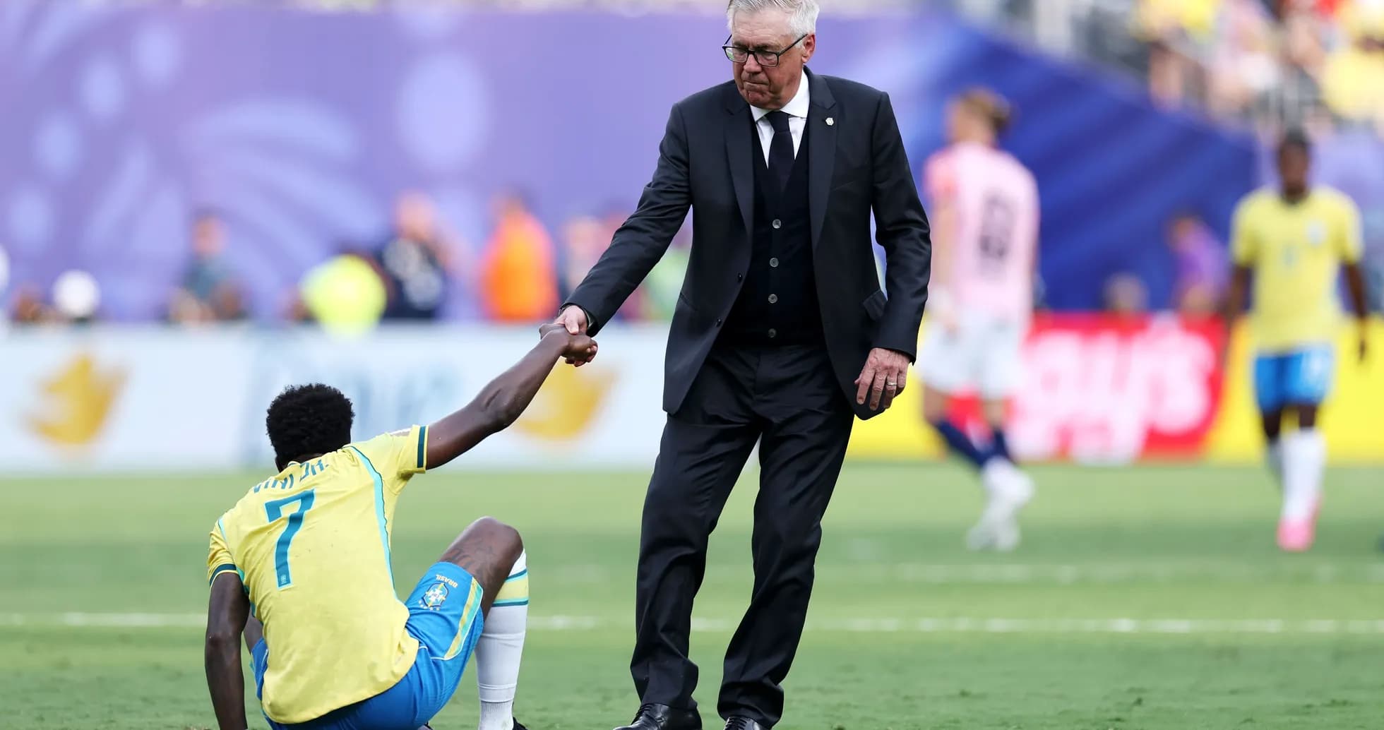 Entrenador ayudando a jugador caído en el campo