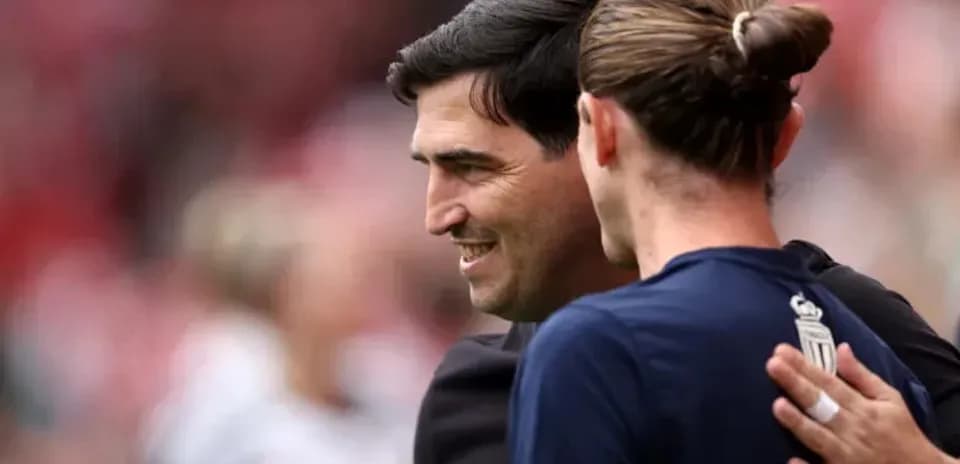 Entrenador y jugador abrazándose en el campo