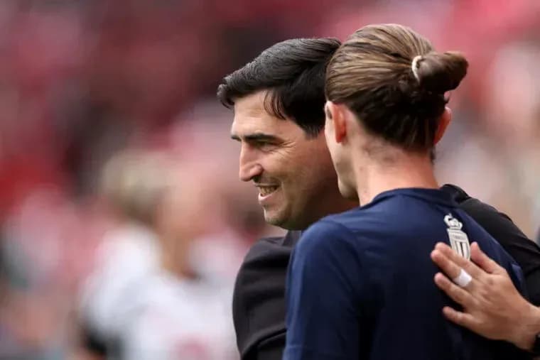 Entrenador y jugador abrazándose en el campo