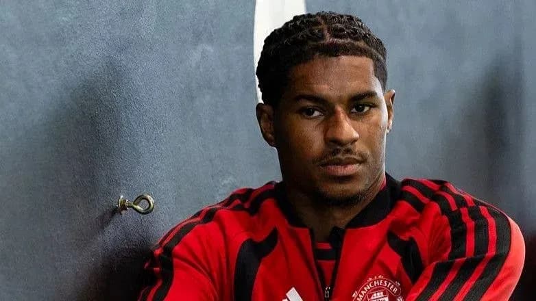 Jugador sentado en vestuario con uniforme rojo