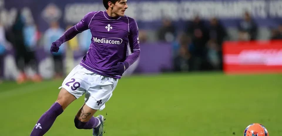 Jugador de Fiorentina corriendo tras el balón en campo