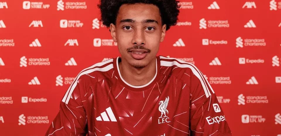 Jugador de Liverpool firmando contrato en mesa